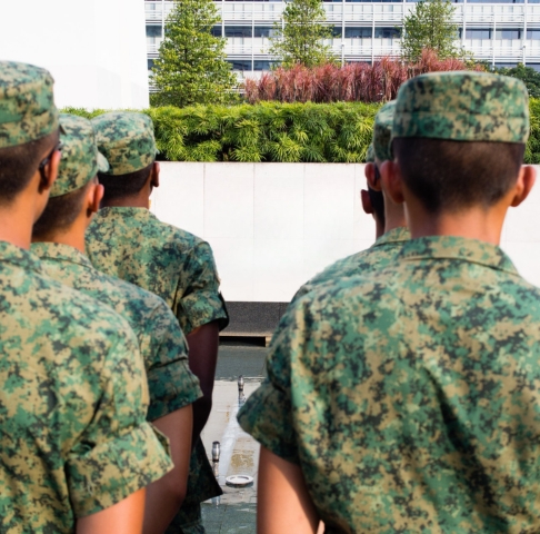 A group of soldiers in a pixelated green uniform standing at attention
